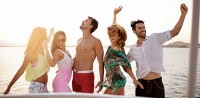 People dancing on a boat at sunset.